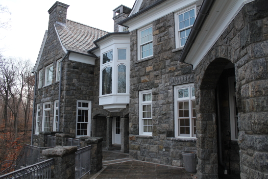Granite home rear with view of portico arches